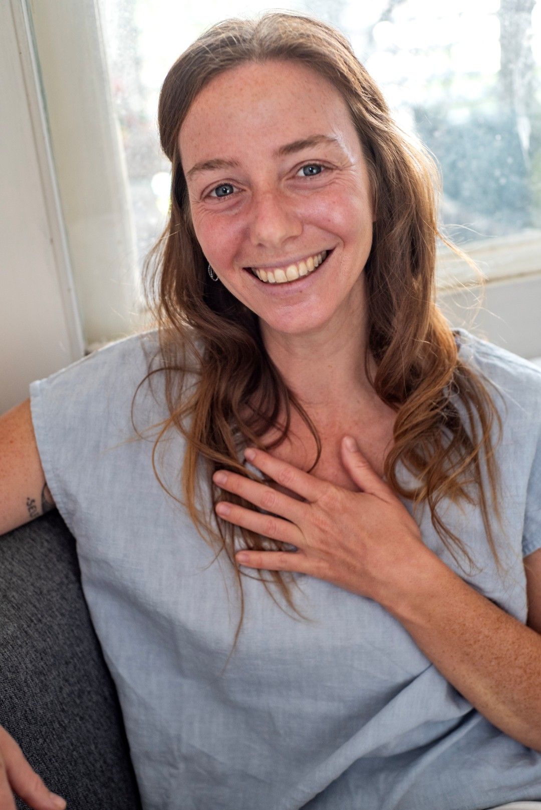 Rena Shoshana, founder of Wellness Edge, smiling with hand on heart